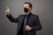 Businessman with surgical medical mask pointing with finger