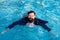 Businessman swimming in suit in the pool. Funny and crazy man in swimming Pool. Business Man having fun by the Pool.
