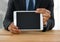 Businessman with tablet at desk with bright background