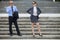 Businessman talking on phone while businesswoman standing on steps