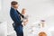 businessman talking on smartphone and holding infant daughter looking