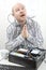 Businessman Tangled In Cables While Praying At Desk