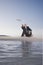 Businessman Throwing Bottle With Message Into Sea