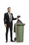 Businessman throwing a waste bag in a garbage bin