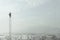 Businessman at the top of a long ladder observes the city with his binoculars