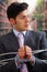 Businessman trapped in a chair with rope, with a chain in his hands, in a blurred background