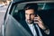 Businessman travelling by taxi and making phone call