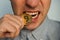 A businessman tries out a gold bitcoin teeth