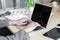 The businessman while typing an information on laptop with office accesssories setting on wood table. /Business and technology con