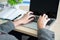 The businessman while typing an information on laptop with office accesssories setting on wood table. /Business and technology con