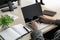 The businessman while typing an information on laptop with office accesssories setting on wood table. /Business and technology con