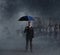 Businessman with umbrella standing over apocalyptic background. Crisis, default, setback concept.