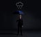 Businessman with umbrella standing under the rain. Dark, dramatic background. Business, failure, crisis, concept.