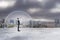 Businessman under glass cover standing on gloomy city background with mock up place.