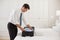 Businessman unpacking luggage at a hotel bedroom