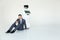 Businessman uses a smartphone while sitting on the floor next to a robot. Modern Robotic Technologies. Humanoid