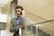 Businessman Using Cellphone While Leaning On Glass Railing