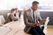 Businessman using a tablet with three colleagues seated behind him