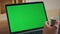 Businessman video calling greenscreen laptop holding coffee cup close up.