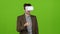 Businessman with virtual glasses looks funny video laughs. Green screen