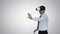 Businessman in virtual reality headset walking in virtual world on gradient background.