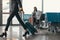 businessman waiting for flight at airport lobby while female pilot