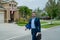 Businessman walk near house in american neighborhood. Business man walk down street, late for a meeting. Business man in