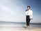 Businessman walking along a beach with laptop