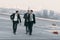 businessman walking with bodyguards in sunglasses and suits