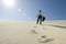 Businessman Walking With Briefcase In Desert