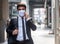 Businessman walking in city with very small amount of people during covid-19 outbreak make phone call and wearing mask