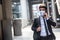 Businessman walking in an empty city during covid-19 outbreak make phone call and wearing mask