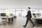 Businessman walking in office interior with city view