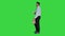 Businessman walking with take away coffee and paper bag with lunch on a green screen, chroma key.