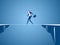 Businessman walking tightrope across the gap between hill. Walking over cliffs.Business risk and success concept.
