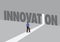 Businessman walking towards a light path with the text innovation. Business concept of business disruption, innovation or digital