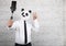 A businessman wearing a panda mask with a sympathetic gesture takes a photo with his mobile phone