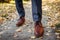 Businessman wearing shoes in autumn park. Brown leather classic footwear. Close up of legs