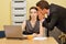 Businessman whispering in businesswoman\'s ear at office
