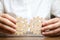 Businessman in white shirt connects two wooden gears. Symbolism of establishing business processes and communication. Improving