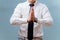 Businessman in white shirt joining his hands, making prayer gesture over blue