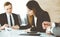 Businessman and woman with colleague sitting and working at the desk. Diverse business people discussing questions at