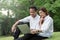 Businessman and woman use laptop in park with happy moment, sit