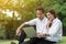 Businessman and woman use laptop in park with happy moment, sit