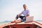 Businessman working with computer on a boat, nice outdoor office.