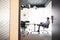 Businessman Working On Laptop At Boardroom Table Viewed Through Meeting Room Door