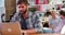 Businessman Working On Laptop In Busy Office