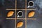 Businessman working morning with cups of hot coffee and sweet croissants on black background. Game of noughts and crosses.