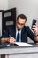 Businessman working in the office and use smartphone, documents on his desk