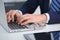 Businessman working by typing on laptop computer. Man`s hands on notebook or business person at workplace. Employment o